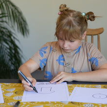 Load image into Gallery viewer, girl drawing her design for her t-shirt
