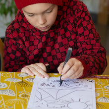 Load image into Gallery viewer, Boy drawing his design for his t-shirt